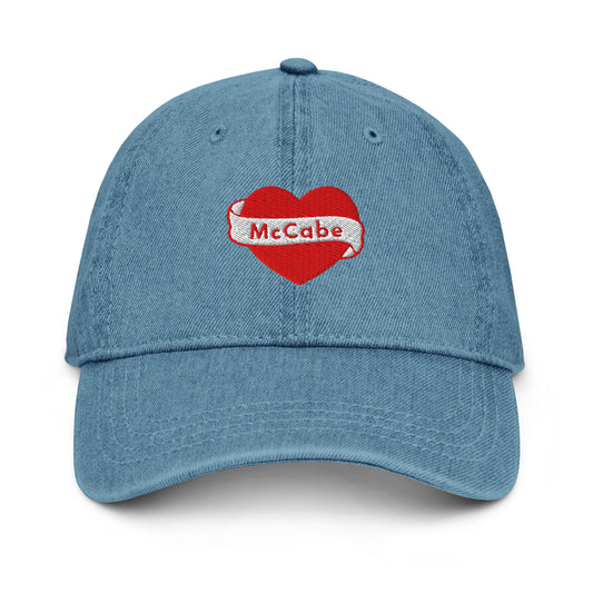 Denim hat with a Katie McCabe heart graphic embroidered on it